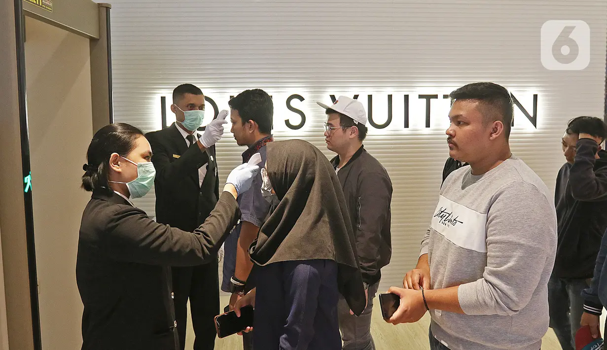 Pengunjung saat diperiksa suhu tubuh sebelum memasuki area gedung The Plaza di Jakarta, Kamis (5/3/2020). Pemeriksaan suhu tubuh tersebut merupakan upaya untuk mengantisipasi merebaknya wabah virus corona atau Covid-19. (Liputan6.com/Herman Zakharia)