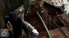 Petugas meninjau tanah longsor di kawasan Kuningan, Setiabudi, Jakarta, Senin (21/11). Longsor ini terjadi karena curah hujan yang meningkat dan kondisi turap yang tidak bisa lagi menahan air. (Liputan6.com/Johan Tallo)
