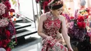 Di momen sangjit jelang menikah, Tina Toon mengenakan Cheongsam merah berhias bordiran bunga tanpa lengan. Cheongsam tersebut dipadukan dengan jubah warna senada. [Instagram].