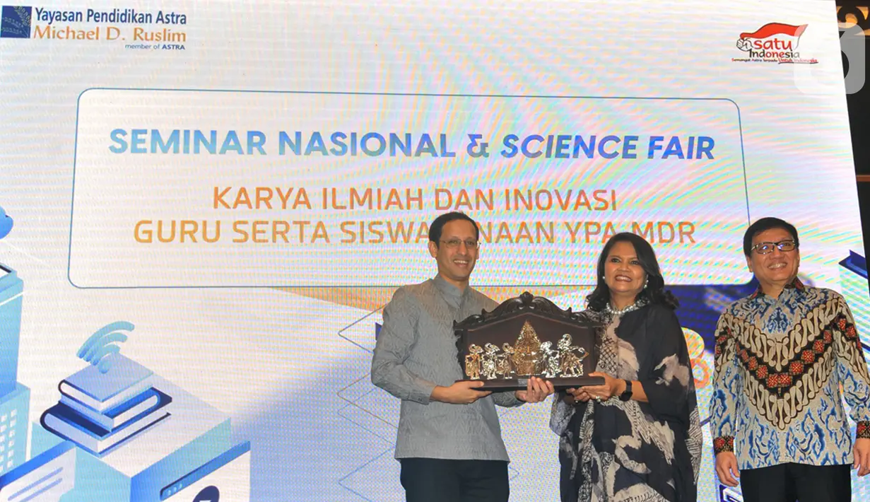 Mendikbud Nadiem Makarim (kiri) menerima cinderamata dari Ketua Pengurus Yayasan Pendidikan Astra Michael D. Ruslim (YPAMDR) Herawati Prasetyo pada peluncuran School Collaboration System (SCS) di Seminar Nasional & Science Fair 2020 di Jakarta, Jumat (24/1/2020). (Liputan6.com/HO/Iwan)