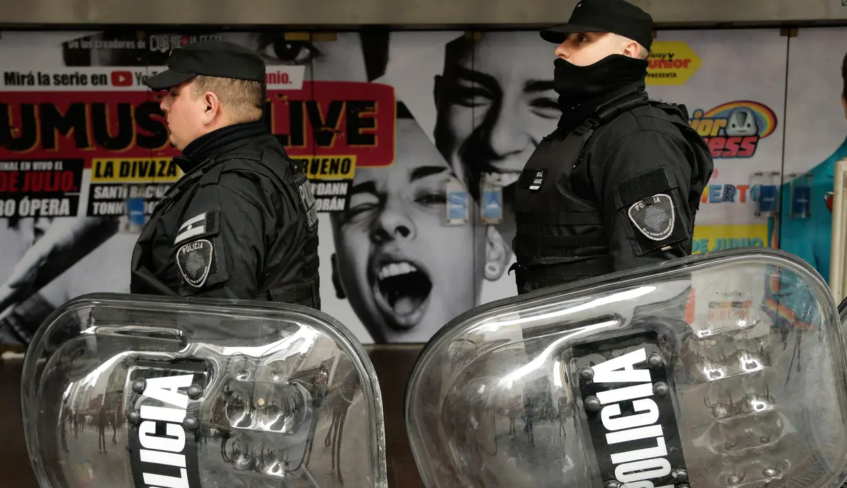 Polisi berpatroli saat ribuan orang berdemonstrasi menentang kebijakan Presiden Mauricio Macri di Buenos Aires, Argentina, Senin (9/7). Demonstran meneriakkan yel-yel "Tanah Air tidak pernah menyerah." (AP Photo/Jorge Saenz)