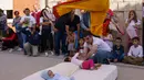 Pria berkostum setan melompati bayi-bayi yang terlentang di atas matras selama tradisi El Salto del Colacho di desa Castrillo de Murcia, Spanyol, Minggu (3/6). Tindakan ini bermakna untuk membersihkan bayi dari roh-roh jahat. (AFP/CESAR MANSO)