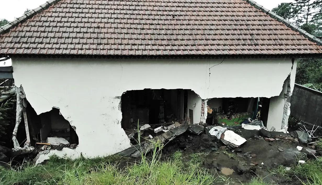 Tembok sebuah rumah mengalami rusak parah akibat tanah longsor yang menimpa Kecamatan Kintamani, Bali, Jumat (10/2). Hujan deras sepanjang Kamis malam menyebabkan longsor di tiga desa di Kecamatan Kintamani. (STR/NATIONAL DISASTER AGENCY/AFP)