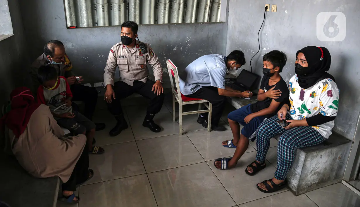 Petugas kesehatan mendata anak-anak saat pelaksanaan vaksinasi COVID-19 Sinovac di Pospol Polsek Pamulang, Tangerang Selatan, Banten, Kamis (6/1/2022). Vaksinasi dilakukan guna mendukung tercapainya target nasional vaksinasi anak sebanyak 26 juta di seluruh Indonesia. (Liputan6.com/Faizal Fanani)