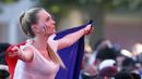 Aksi fans cantik Prancis dengan membentangkan bendera diareal fan zone saat timnya melawan Jerman pada semifinal piala Eropa 2016 di Paris, (7/7/2016). (REUTERS/Regis Duvignau)