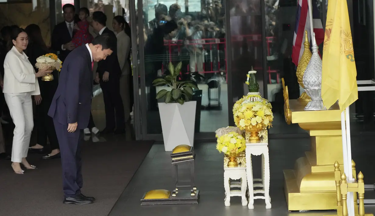 Mantan pemilik Manchester City itu muncul sebentar dari gedung terminal untuk membungkuk dan memberikan karangan bunga di depan foto Raja Maha Vajiralongkorn sebagai tanda penghormatan. (AP Photo/Sakchai Lalit)