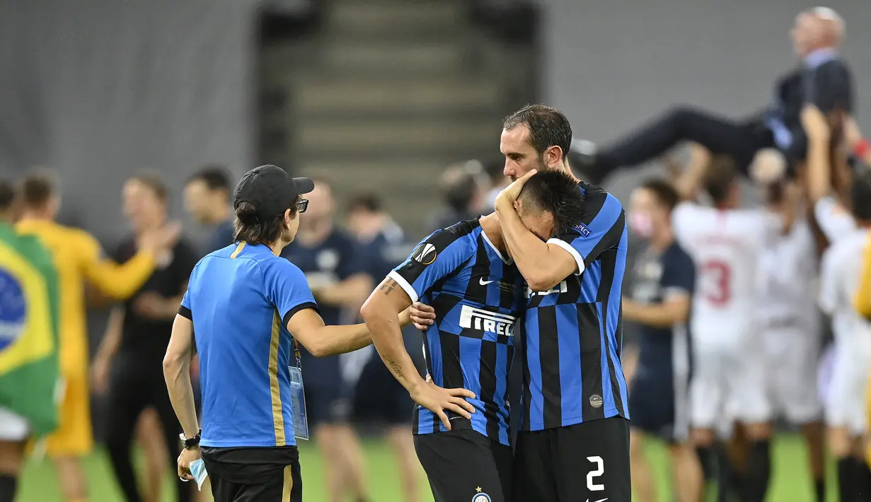 Pemain Inter Milan, Diego Godin, menenangkan Lautaro Martinez usai gagal meraih gelar juara Liga Europa 2019/2020 di Stadion RheinEenergie, Sabtu (22/8/2020) dini hari WIB. Inter Milan kalah 2-3 atas Sevilla. (AFP/Martin Meissner/pool)