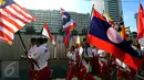 Sejumlah remaja membawa bendera negara-negara peserta Sea Games di Jakarta, Minggu (30/4). Kirab itu berlangsung guna menyambut Sea Games Kuala Lumpur 2017. (Liputan6.com/Johan Tallo)