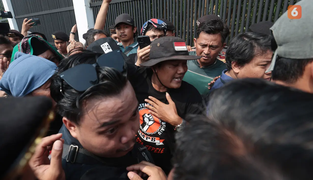 Koordinator Aliansi Masyarakat Pati Bersatu (AMPB) Supriyono alias Botok, didampingi sejumlah rekan pendemo, memasuki gedung DPR dengan pengawalan petugas kepolisian saat aksi di Jakarta, Kamis (27/8/2026). (KLY/Budy Santoso)