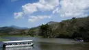 Para wisatawan menggunakan sebuah perahu menyusuri Sungai Tarcoles, Rio Grande, Kosta Rika, Jumat (13/3/2015). Buaya menjadi daya tarik objek wisata Sungai Tarcoles. (AFP Photo/Ezequiel Becerra) 