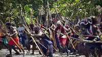 Puluhan orang membawa panah saat akan melaksanakan ritual adat kremasi jenazah korban perang suku di Timika, Papua, Senin (18/1). (Antara)