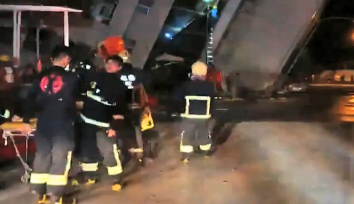 Petugas penyelamat berada di dekat bangunan yang miring untuk berusaha mengevakuasi korban usai terjadi gempa di di Hualien, Taiwan (7/2). (EBC via AP)