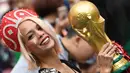 Suporter wanita tersenyum sambil memegang replika trofi Piala Dunia sebelum pertandingan grup A Piala Dunia 2018 antara Rusia dan Arab Saudi di stadion Luzhniki di Moskow, (14/6). (AFP Photo / Kirill Kudryavtsev)