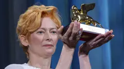 Aktris Tilda Swinton memegang trofi Golden Lion for Lifetime Achievement pada upacara pembukaan Venice Film Festival ke-77 di Venesia, Italia, Rabu (2/9/2020). Venice Film Festival tahun ini akan berlangsung dari 2 September hingga 12 September. (AP Photo/Domenico Stinellis)
