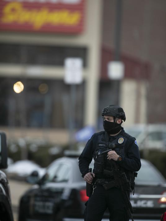 Polisi berjaga di tempat kejadian di luar toko kelontong King Soopers tempat penembakan terjadi di Boulder, Colorado (22/3/2021). Peristiwa penembakan mematikan ini tercatat yang kedua kalinya dalam tempo kurang dari sepekan. (AP Photo/David Zalubowski)