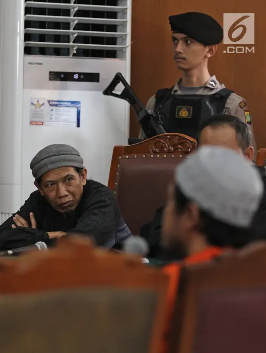 Terdakwa bom Thamrin, Aman Abdurrachman mendengarkan keterangan saksi dalam sidang lanjutan di Pengadilan Negeri Jakarta Selatan, Selasa (27/3). Sidang kasus bom Thamrin ini beragenda mendengarkan keterangan tiga orang saksi (Liputan6.com/Herman Zakharia)