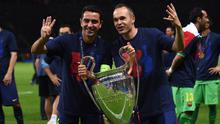 Xavi dan Iniesta berpose dengan tropi Liga Champions di Olympiastadion, Berlin, Minggu (7/6/2015). Di final, Barcelona kandaskan Juventus dengan skor 3-1. (AFP Photo/Patrik Stollarz)