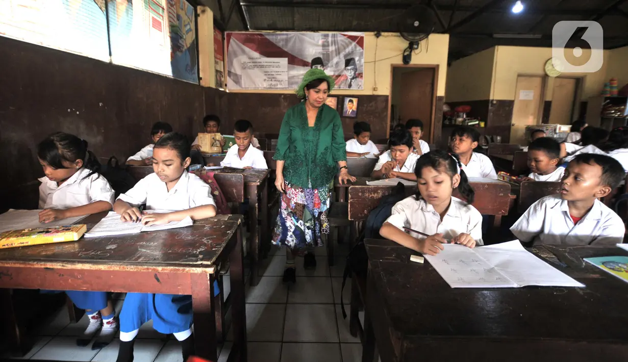 Sri Rossyati memberikan materi pengajaran kepada siswa Sekolah Darurat Kartini di kawasan Lodan, Jakarta Utara, Senin (25/11/2019). Sekolah Darurat Kartini didirikan pada tahun 1990 an oleh dua wanita kembar asal Yogyakarta, Sri Rossyati dan Sri Irianingsih. (merdeka.com/Iqbal Nugroho)