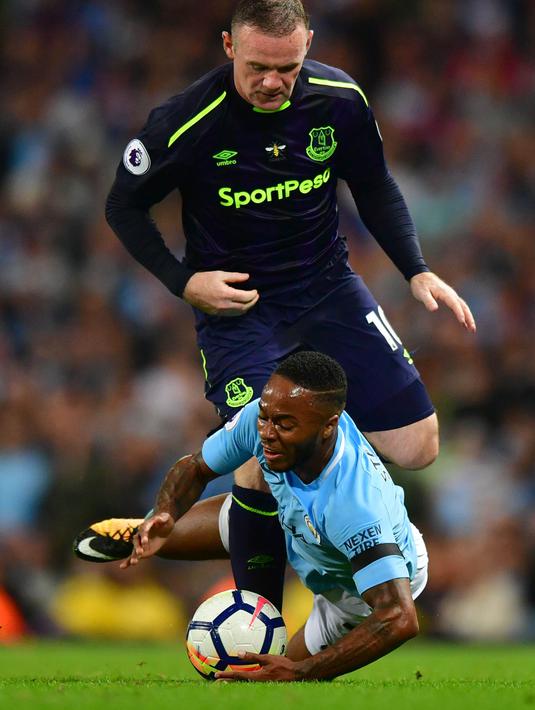 Gelandang Manchester City, Raheem Sterling, berebut bola dengan striker Everton, Wayne Rooney, pada laga Premier League di Stadion Etihad, Selasa (22/8/2017). Rooney berhasil mencetak gol ke 200 di ajang Premier League. (AFP/ Anthony Devlin)