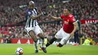 Pemain West Bromwich, Allan Nyom (kiri) berebut bola dengan pemain Manchester United, Anthony Martial pada lanjutan Premier League di Old Trafford, Manchester,(15/4/2018). Manchester United kalah 0-1. (Nick Potts/PA via AP)