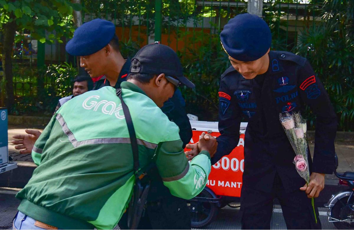 FOTO: Aksi Damai Ojol Tebar Mawar untuk Perdamaian