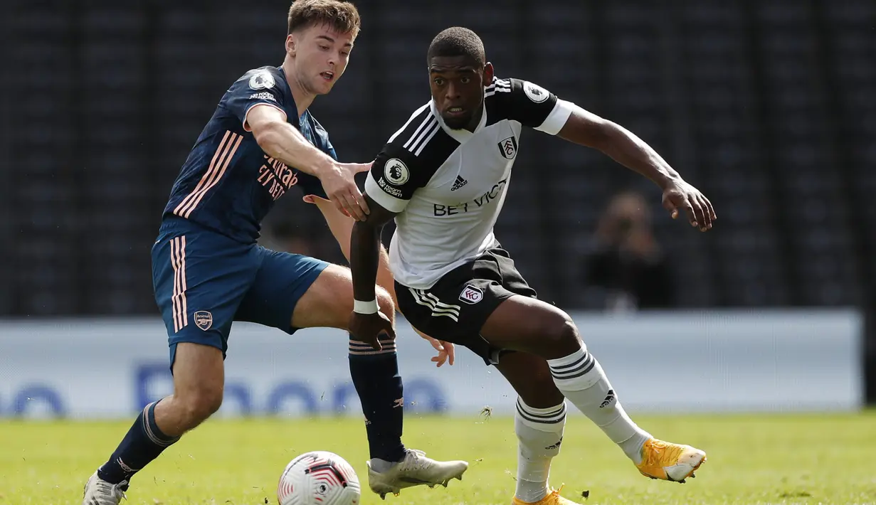 Bek Arsenal, Kieran Tierney, berebut bola dengan penyerang Fulham, Ivan Cavaleiro, pada laga Liga Inggris di Craven Cottage, London, Sabtu (12/9/2020) malam WIB. Arsenal menang 3-0 atas Fulham. (Paul Childs/Pool via AP)