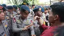 Seorang petugas kepolisian berusaha menenangkan mahasiswa yang memprotes karena dihalangi saat hendak menuju gedung DPR untuk menyampaikan aspirasi di Jakarta, Kamis (27/8/2026). (KLY/Budy Santoso)
