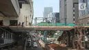 Pekerja menyelesaikan pembangunan JPO Stasiun LRT Rasuna Said di Jakarta, Senin (11/7/2022). Jadwal uji coba LRT Jabodebek batal dilakukan pada 17 Agustus 2022 dan direncakanan digelar pada Desember 2022 karena adanya kendala dalam skema pembiayaan pembangunan LRT Jabodebek. (Liputan6.com/Faizal Fanani)