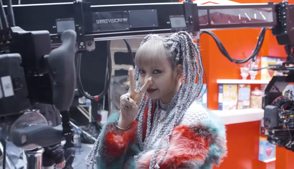 Lisa dengan ikatan rambutnya yang unik menyapa kamera dalam video pembuatan video musik Kill This Love. (Sumber: YouTube/BLACKPINK)