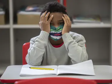 Seorang siswa mengenakan masker pada hari pertama kembali ke kelas tatap muka di tengah pandemi COVID-19 di sekolah umum Raul Antonio Fragoso di Sao Paulo, Brasil (8/2/2021). Pemerintah negara bagian Sao Paulo telah mengizinkan sekolah tatap muka. (AP Photo/Andre Penner)