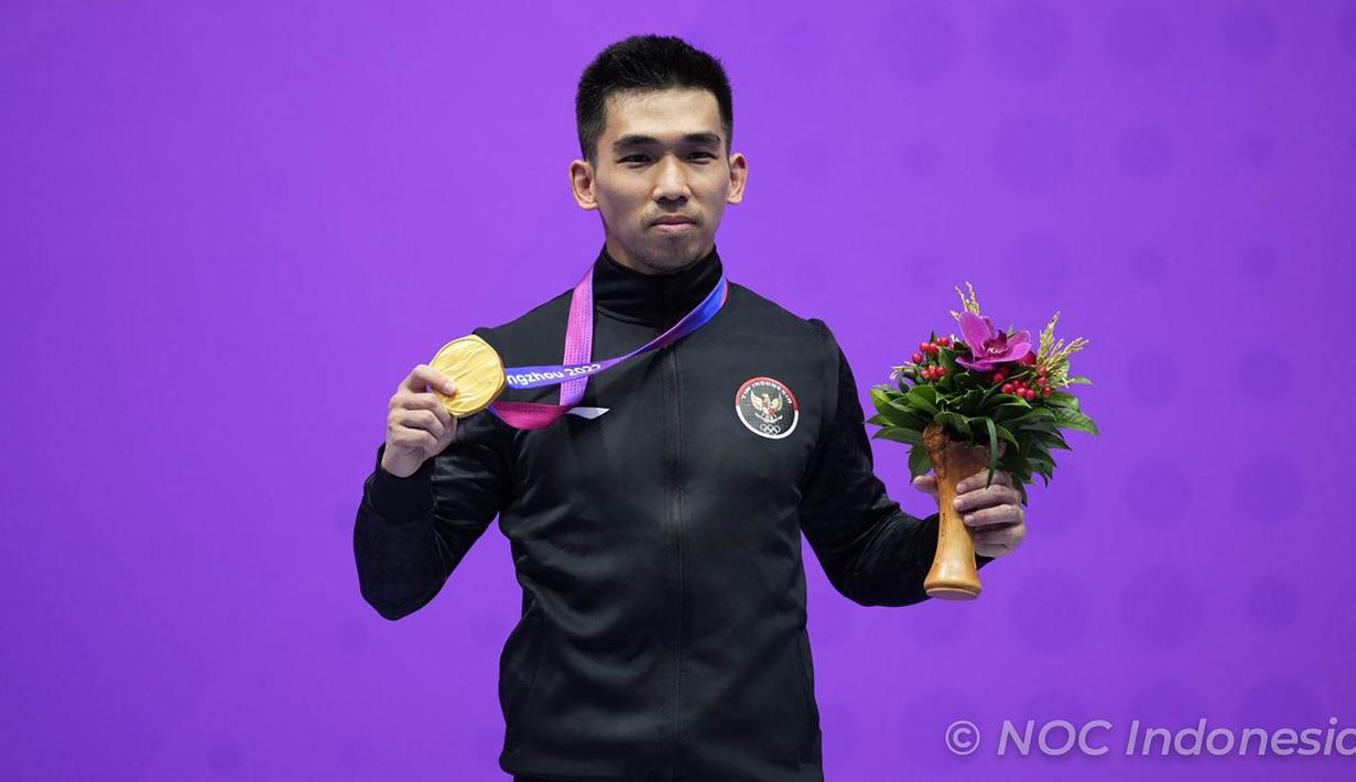 Selebrasi atlet wushu Indonesia, Harris Horatius dengan medali emas di atas podium usai memenangi lomba nomor men’s nanquan dan nangun all-around Asian Games 2022 di XSG Sports Centre, Hangzhou, China, Selasa (26/9/2023). (NOC Indonesia/Tetuko Mediantoro)