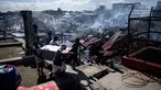 Sejumlah warga membawa barang miliknya saat rumah-rumah mereka hangus terbakar di sebuah daerah kumuh di Navotas, Manila (8/11). Dilaporkan sekitar 150 keluarga terkena dampak kebakaran tersebut. (AFP Photo/Noel Celis)