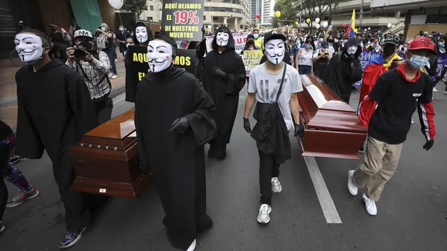 Para pengunjuk rasa membawa peti mati kosong selama pemogokan nasional untuk memprotes reformasi pajak yang diusulkan pemerintah, di ibu kota Kolombia, Bogota, pada Rabu (28/4/2021). (AP Photo/Fernando Vergara)