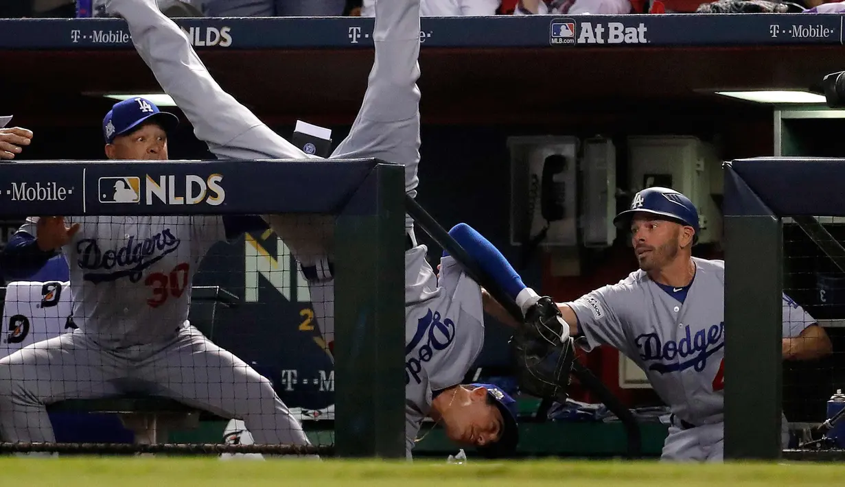 Pemain Los Angeles Dodgers, Cody Bellinger terjatuh setelah menangkap bola tembakan pemain Arizona Diamondbacks, Jeff Mathis saat pertandingan kelima dalam game 3 dari Divisi Liga Nasional baseball di Phoenix (9/10). (AP Photo/Rick Scuteri)