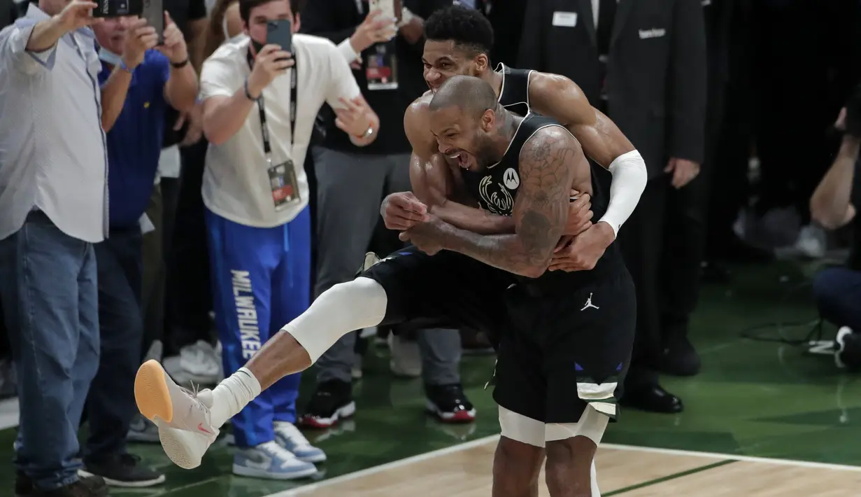 Pebasket Milwaukee Bucks Giannis Antetokounmpo memeluk rekannya P.J. Tucker setelah mengalahkan Phoenix Suns di Game 6 Final NBA bola basket di Milwaukee, Selasa (20/7/2021). Bucks menang 105-98. (AP Photo/Aaron Gash)