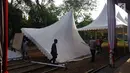 Pekerja mendirikan atap tenda untuk relawan di Jalan Setiabudi, Medan, Senin (20/11). Dari pantauan Liputan6.com, tenda ini berada cukup jauh dari rumah Bobby Nasution yang dijadikan tempat acara. Kira-kira sejauh 1 kilometer. (Liputan6.com/Aditaya Eka)