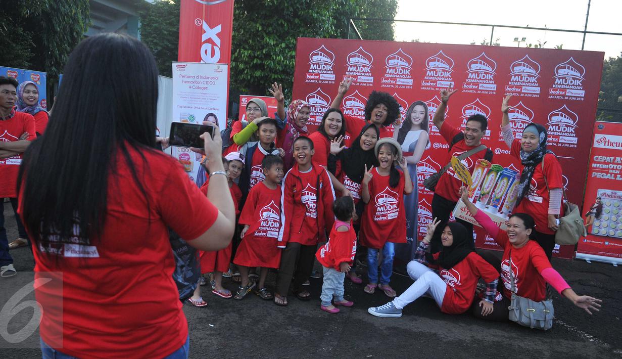 Peserta berfoto sebelum keberangkatan mudik kemenangan Bodrex dan Neo Rheumacyl di Tenis Indoor Senayan, Jakarta, Kamis (30/6). Mudik yang diikuti 2000 orang ini melibatkan 41 bus dengan berbagai tujuan kota di Pulau Jawa. (Liputan6.com/Gempur M Surya)