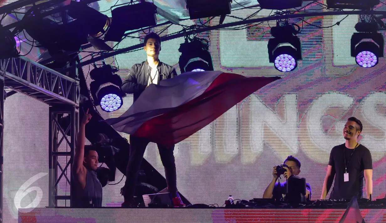 Seorang DJ mengibarkan bendera merah putih pada acara DWP 2016, di Kemayoran, Jakarta, Jumat. (09/12). DJ Alan Walker dan DJ Valentino Khan menjadi penutup di panggung Neon Jungle. (Liputan6.com/Fery Pradolo)