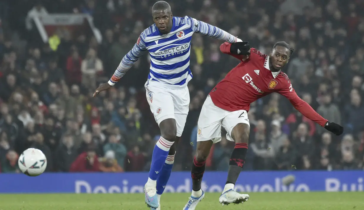 <p>Bek Manchester United, Aaron Wan-Bissaka mengumpan bola dari kawalan pemain Reading, Lucas Joao selama pertandingan putaran keempat Piala FA di Old Trafford di Manchester, Inggris, Minggu (29/1/2023). MU menang atas Reading 3-1. (AP Photo/Rui Vieira)</p>