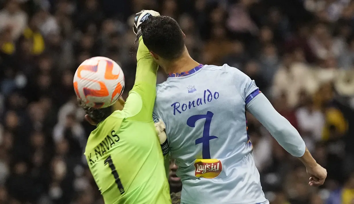 Cristiano Ronaldo melakukan sundulan berusaha dari hadangan kiper PSG Keylor Navas selama pertandingan persahabatan melawan PSG di Stadion Universitas King Saud, di Riyadh, Arab Saudi, 19 Januari 2023. PSG mengalahkan Riyadh All Star dengan skor 5-4. (AP Photo/Hussein Malla)