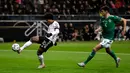 Gelandang Timnas Jerman, Serge Gnabry mengontrol bola dengan dibayangi pemain Irlandia Utara pada laga Grup C Kualifikasi Piala Eropa 2020 di Commerzbank Arena, Selasa (19/11/2019). Timnas Jerman benamkan Irlandia Utara dengan skor telak 6-1 berkat bantuan hat-trick dari Gnabry. (AP/Michael Probst)