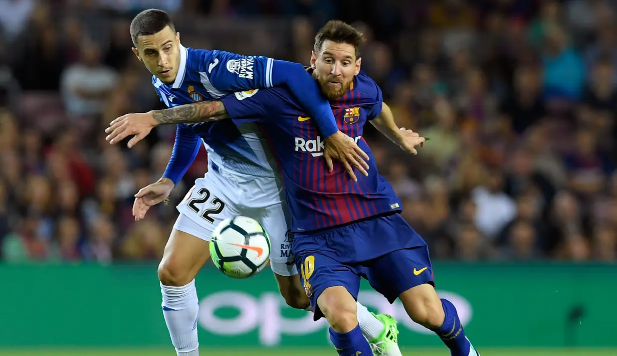 Penyerang Barcelona, Lionel Messi berebut bola dengan bek Espanyol Mario Hermoso saat pertandingan Liga Spanyol di stadion Camp Nou, Barcelona (9/9). (AFP Photo/ Lluis Gene)