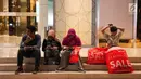 Sejumlah orang menunggu kendaraan sambil membawa barang belanjaannya usai mengunjungi Midnight Sale" di Mall Senayan City, Jakarta, Jumat (16/6). (Liputan6.com/Gempur M Surya)