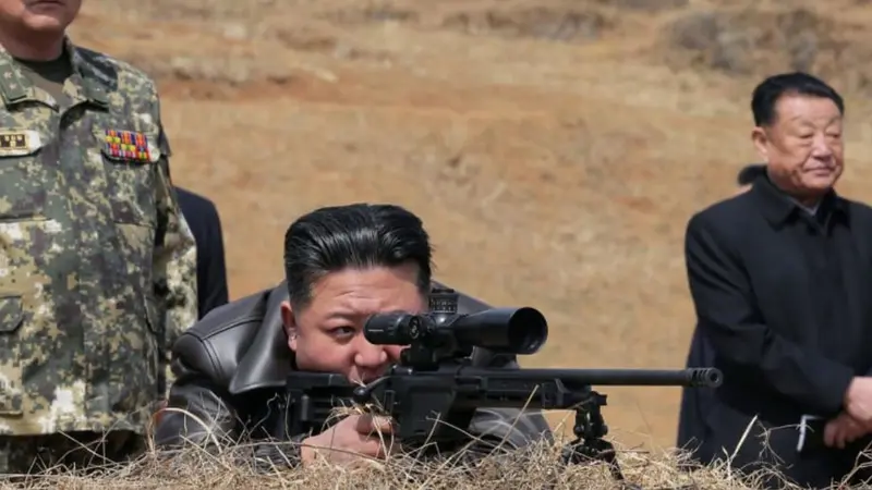Pemimpin Korea Utara Kim Jong Un melihat melalui teropong senapan saat mengunjungi pangkalan pelatihan pasukan operasi khusus Tentara Rakyat Korea untuk mengamati sesi pelatihan komprehensif di lokasi yang dirahasiakan di Korea Utara.