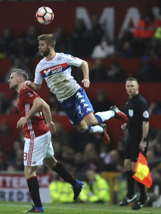 Aksi pemain Manchester United, Luke Shaw (kiri) berduel dengan pemain Wigan Athletic, Alex Gilbey pada putaran keempat Piala FA di Old Trafford, Manchester,  (29/1/2017). Manchester United menang 4-0. (AP/Rui Vieira)