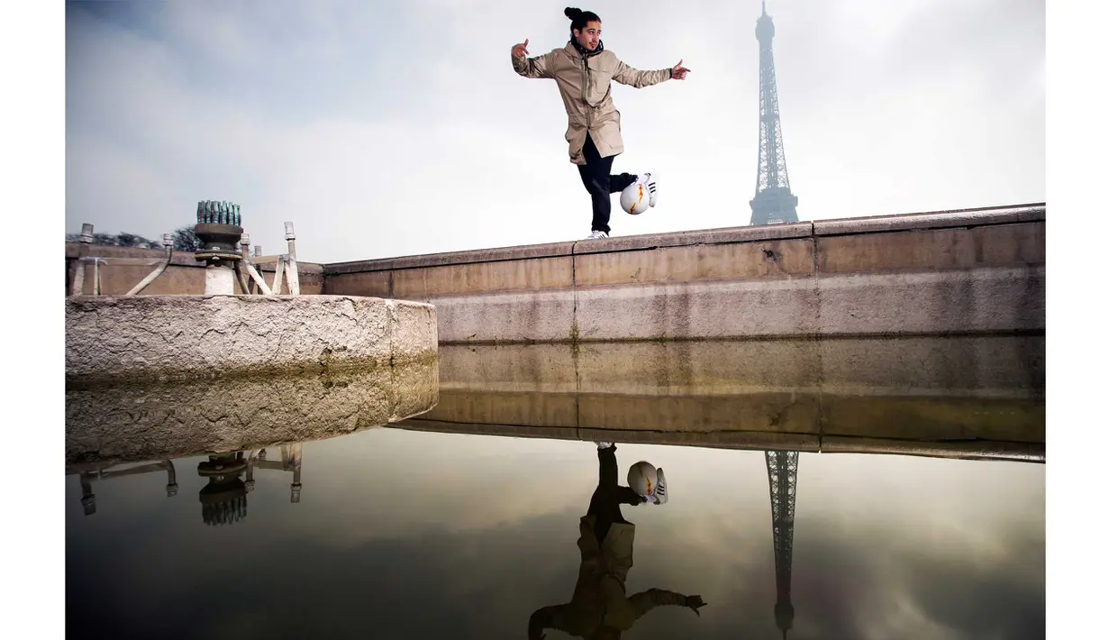 Andreas beraksi bersama bola di Place du Trocadero, dengan  latar menara Effeil, Paris, Jumat (18/3/2016).  S3 Society akan tampil pada Euro 2016 Pracis tanggal 10 Juni-10 Juli 2016. (AFP/Lionel Bonaventure)