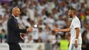 Pelatih Real Madrid, Zinedine Zidane, bersalaman dengan Karim Benzema usai mengalahkan Barcelona di Stadion Santiago Barnabeu, Rabu, (16/8/2017). Karim Benzema resmi memperpanjang masa bakti bersama Los Blancos hingga Juni 2021. (AFP/Gabriel Bouys)