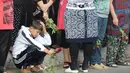 Seorang bocah bersedih saat menunggu datangnya mobil iring-iringan yang membawa peti jenazah Islam Karimov di Tashkent, Uzbekistan, (3/9). Pemerintah Uzbekistan mengkonfirmasi bawah Presiden Islam Karimov telah tiada. (REUTERS/Muhammadsharif Mamatkulov)