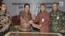 Menteri Agraria dan Tata Ruang/Badan Pertahanan Nasional (ATR/BPN) Sofyan A. Djalil (kedua kiri) bersalaman dengan Dirut PT Pegadaian (Persero) Sunarso (kedua kanan) saat penandatanganan kerjasama di Jakarta, Rabu (18/4). (Liputan6.com/Angga Yuniar)