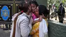 Seorang gadis dipeluk oleh anggota keluarganya setelah diselamatkan dari lokasi banjir bandang di kamp Trishuli, Distrik Nuwakot, Nepal, Jumat, 28 Agustus 2026. (AFP/ Arun Sankar)